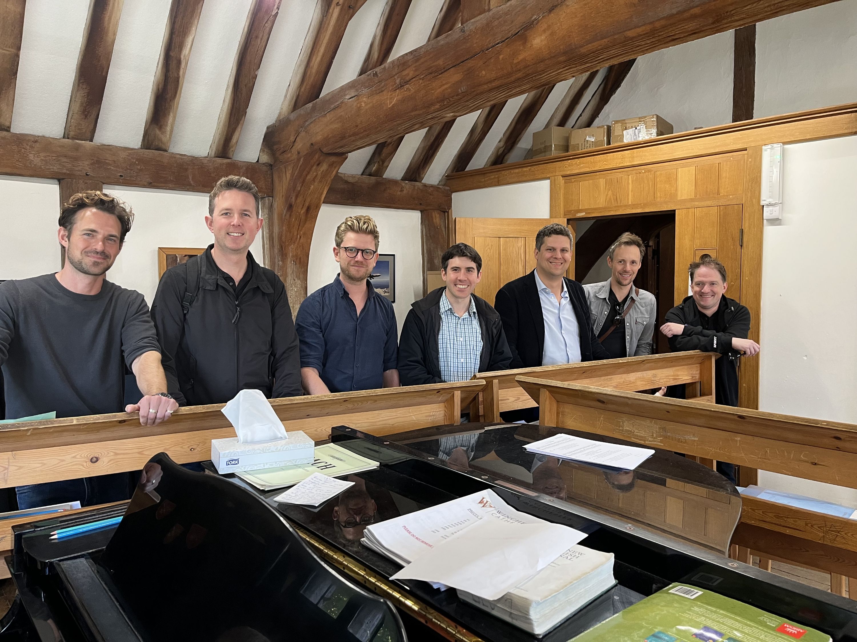 Group of Alumnni at piano in the Priory music room
