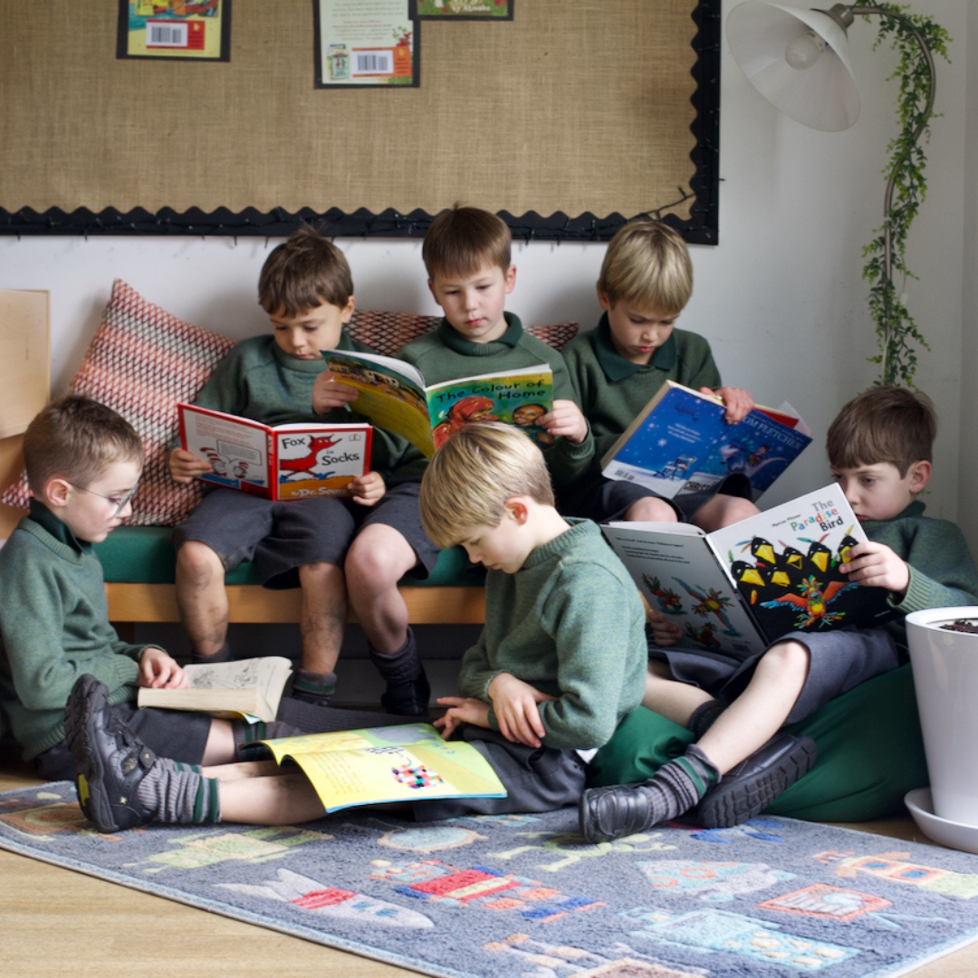image of boys reading in a group on the carpet