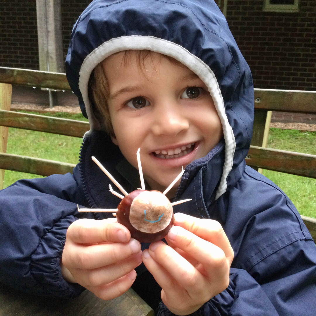 Boy making a spider out of a conker