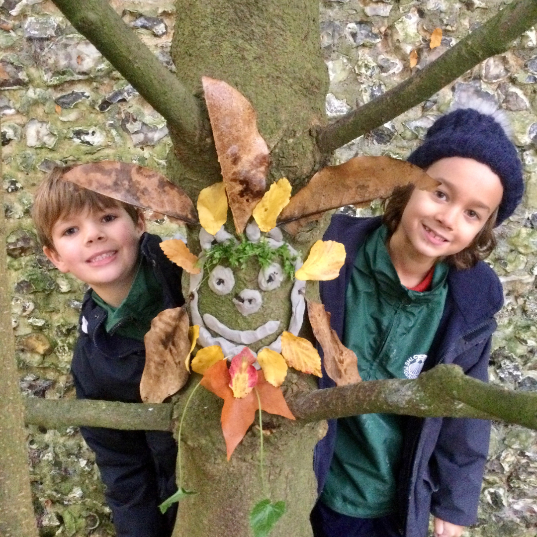 Chilkdren outside creating a mask from woodland items